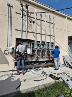 Technicians working on a commercial electrical service installation